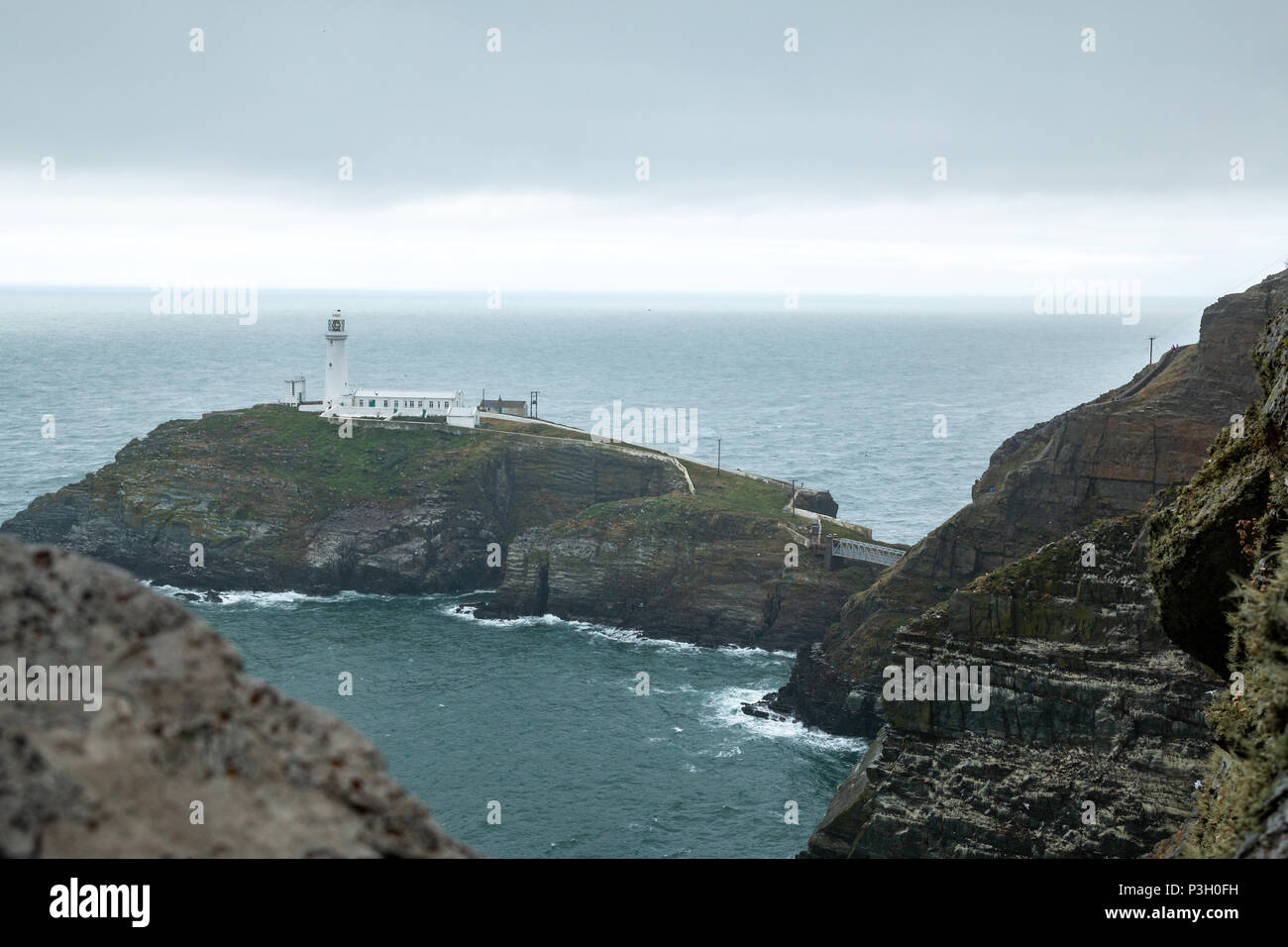 Die historische South Stack Leuchtturm auf einer kleinen Insel über ein Gefälle von 400 Schritten den steilen Klippen erreicht Festland entfernt. South Stack Rock l Stockfoto