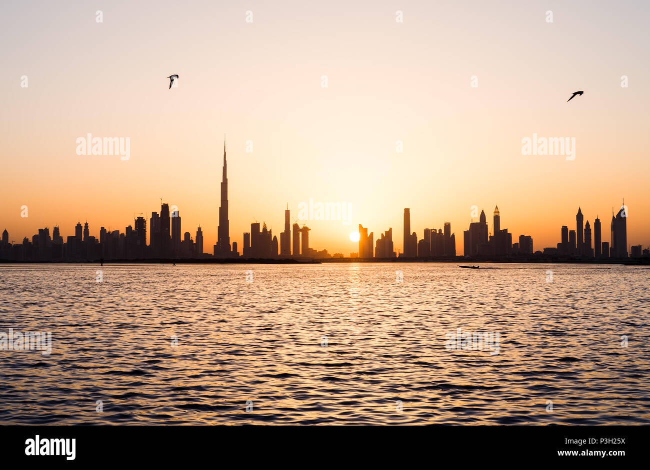 Panoramablick auf Dubai Stadtbild über Wasser bei Sonnenuntergang Stockfoto