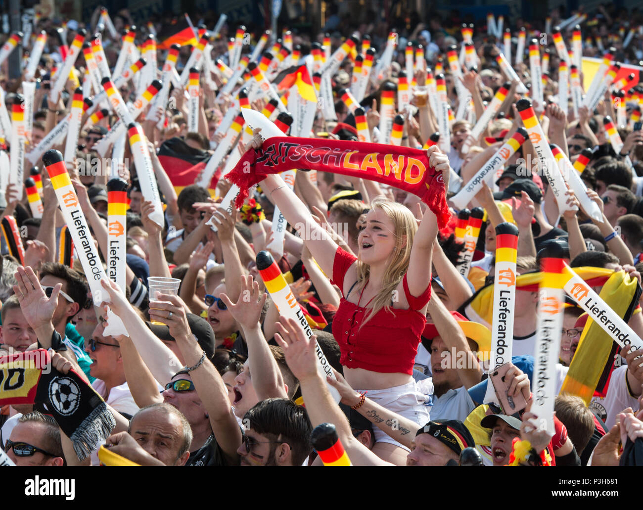 Mit Blick auf die Fanmeile. Ein weiblicher Fan zeigt eine Deutschland Schal  in die Höhe. Fanmeile am Brandenburger Tor und auf der Straße des 17. Juni,  für das erste Spiel der Deutschen