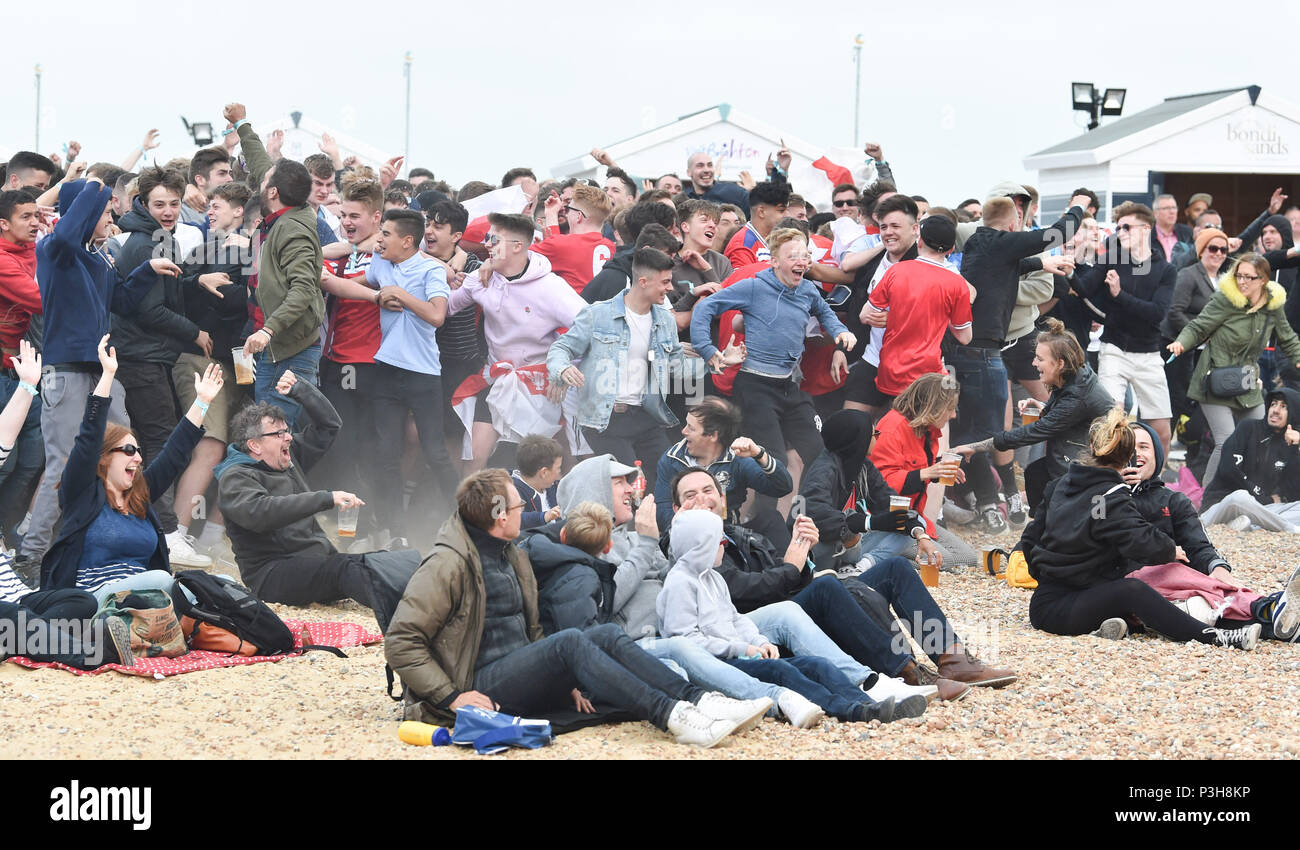 Brighton, UK. 18 Juni, 2018. England Fußball Fans auf das Spiel auf einem riesigen Bildschirm auf Brighton Seafront feiern, als Harry Kane gibt Ihnen eine frühe Leitung: Simon Dack/Alamy leben Nachrichten Stockfoto