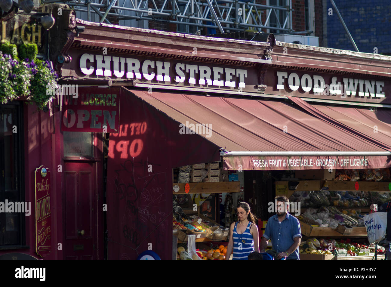 Essen Wein und Obst für den Verkauf auf Stoke Newington Church Street an einem hellen, sonnigen Tag in London unter einem roten Markise Stockfoto