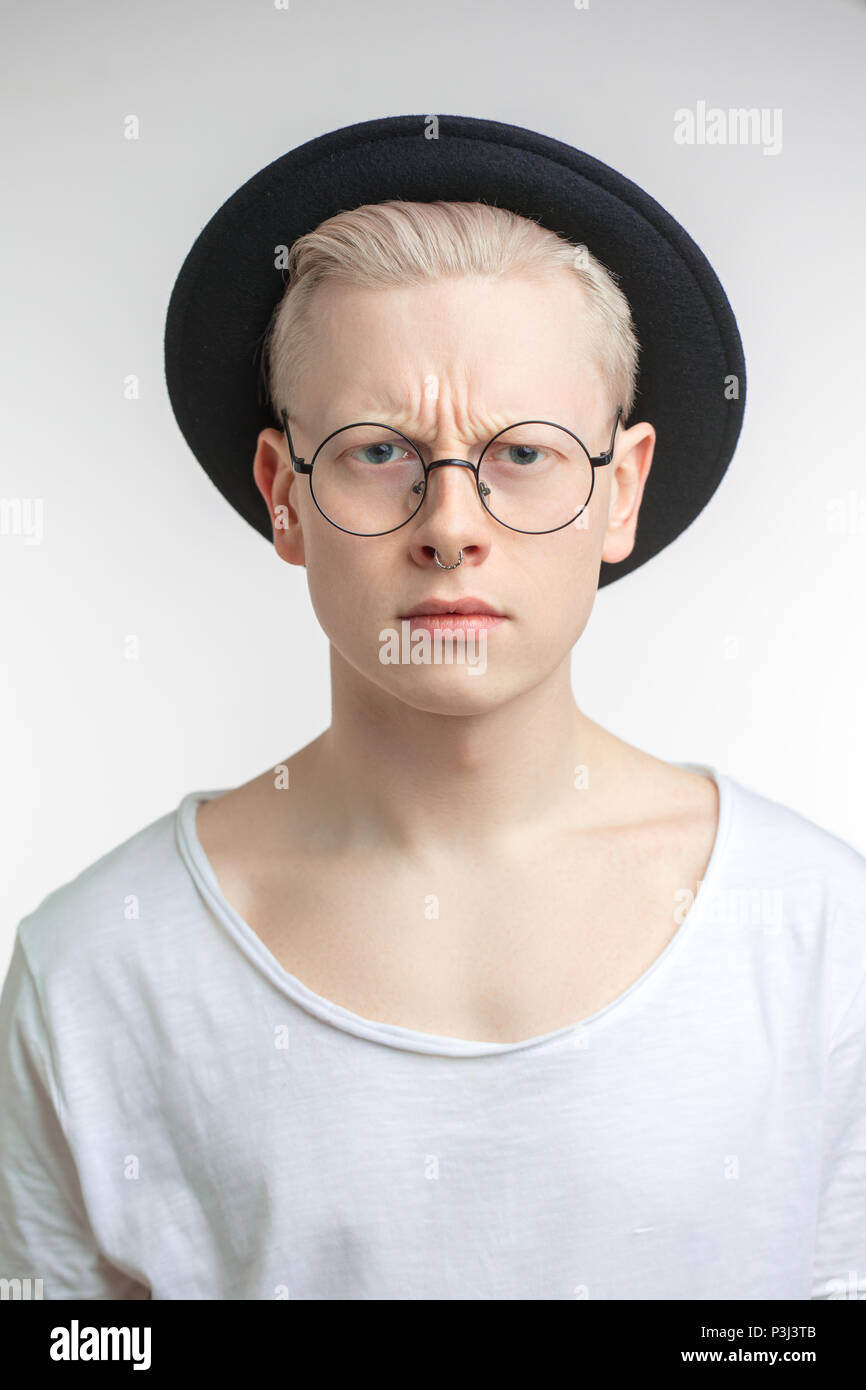 Verärgert blonden Mann in schwarzen Hut mit runzelte die Stirn, Gesicht, als recieving unangenehme Nachrichten Stockfoto