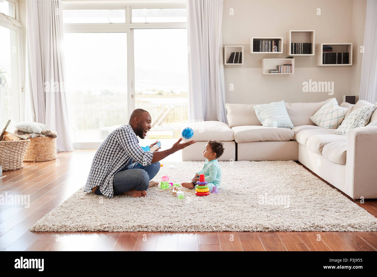 Schwarze Vater und Kind Sohn spielen im Wohnzimmer Stockfoto
