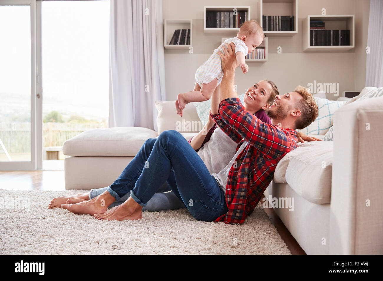 Junge weiße Paar spielen mit Ihrem Kind im Wohnzimmer Stockfoto