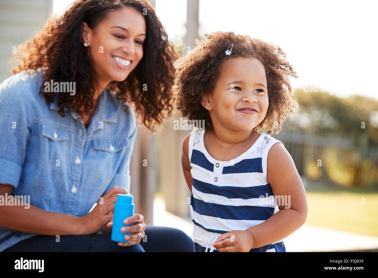 Junge Mischlinge Mutter und Tochter blasen Außen abblasen Stockfoto