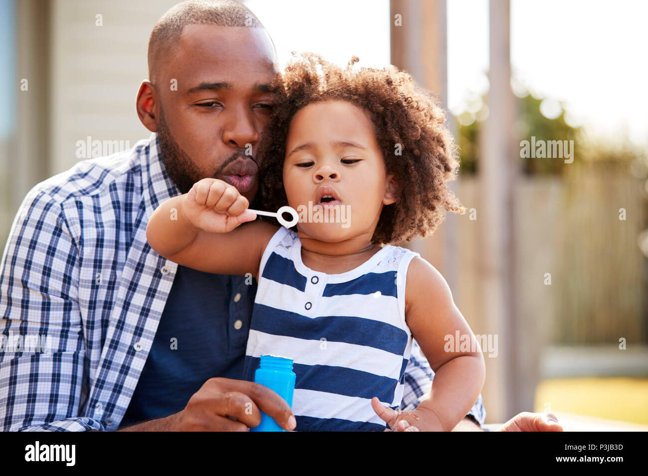 Junge schwarze Vater und Tochter blasen Außen abblasen Stockfoto