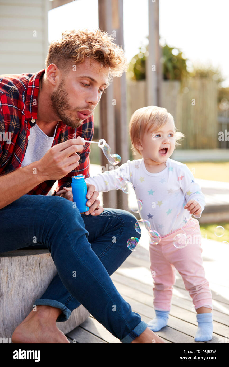 Junge weiße Vater und Tochter Seifenblasen im Freien Stockfoto