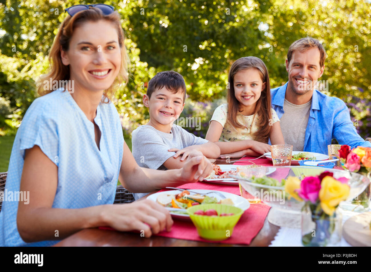 Eltern und Kinder einen gemeinsamen Mittagessen im Garten Stockfoto