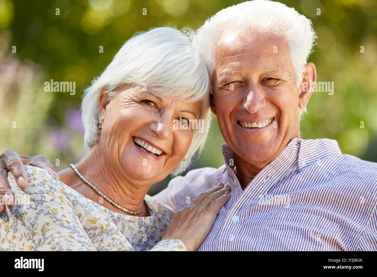 Gerne älteres Paar Umarmung im Garten, Kopf und Schultern Stockfoto