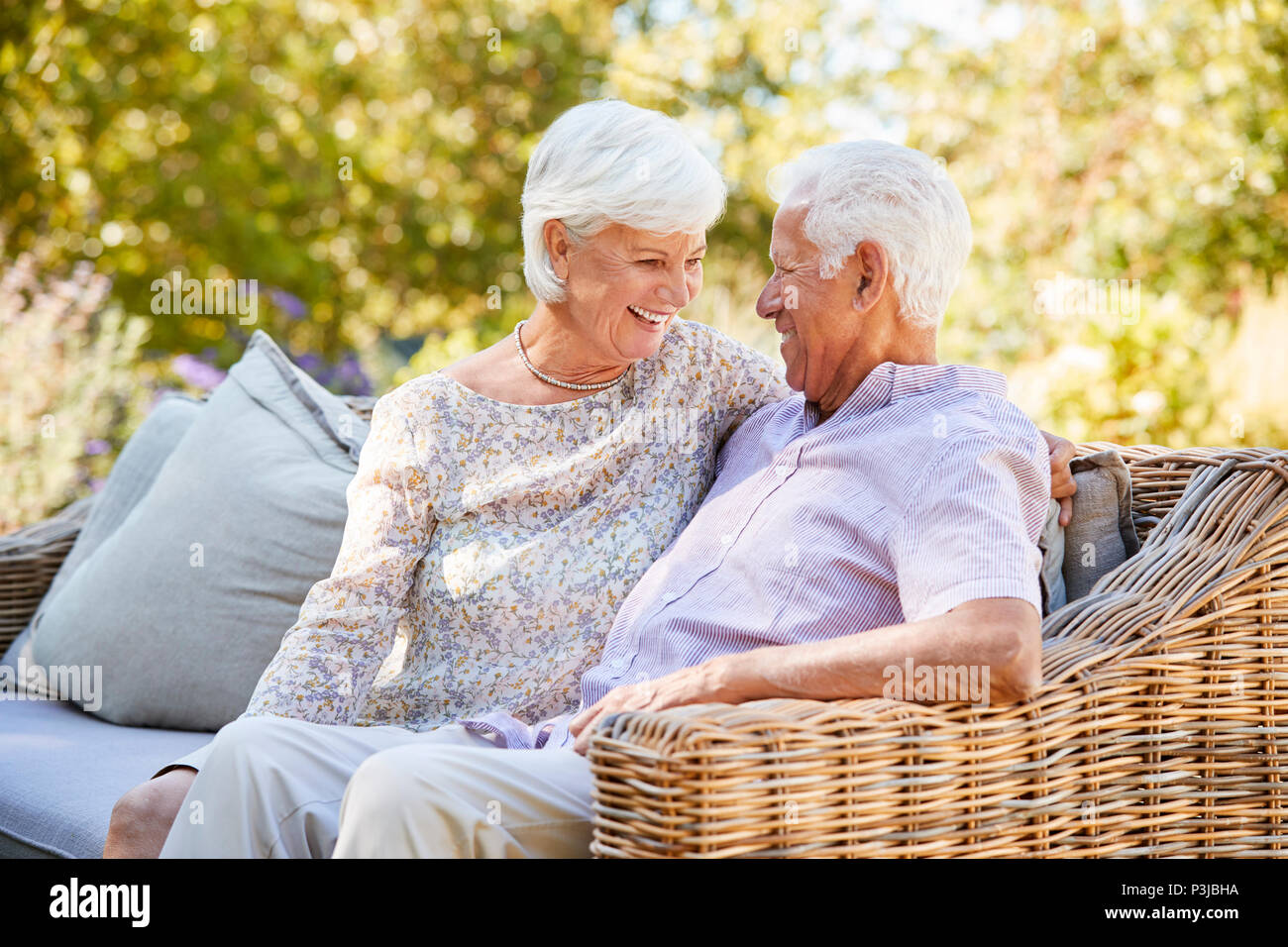 Gerne älteres Paar sitzt im Garten an jedem anderen Suchen Stockfoto