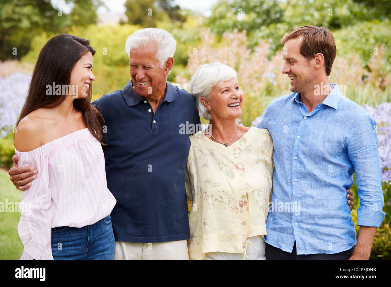 Ältere Eltern mit erwachsenen Kindern auf Spaziergang im Park Stockfoto