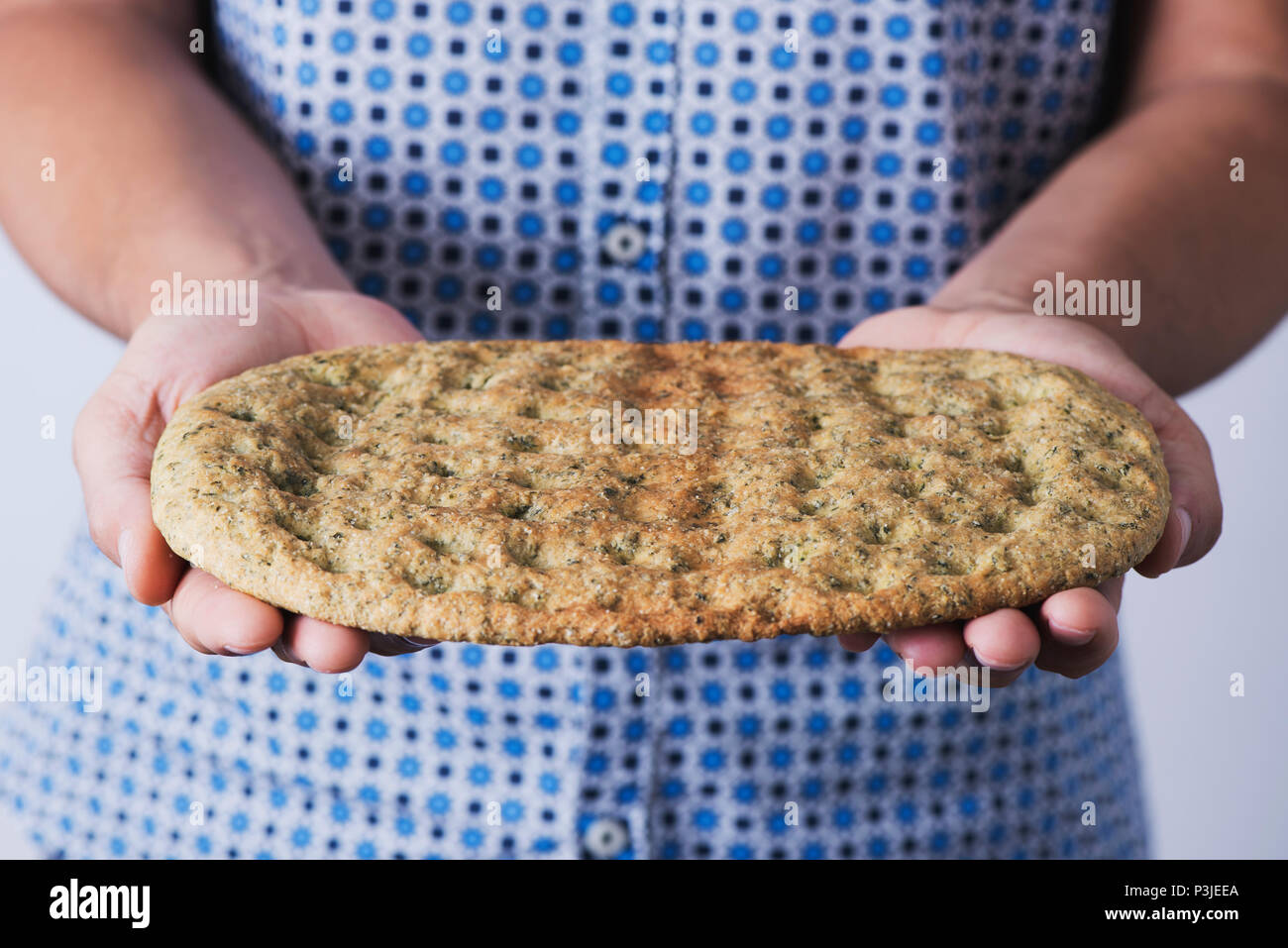 Nahaufnahme von einem kaukasischen Mann mit einem kale Fladenbrot in seinen Händen Stockfoto