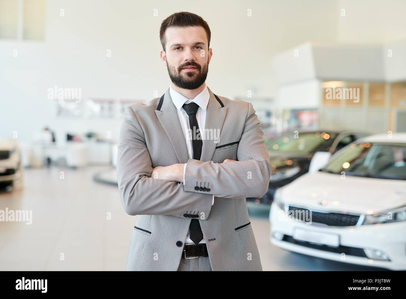 Reifen Geschäftsmann posiert in Autohaus Stockfoto