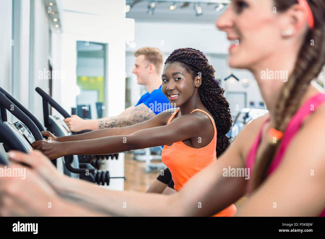 Lächelnde Frau auf Laufband im Fitnessstudio modern Health Club Stockfoto
