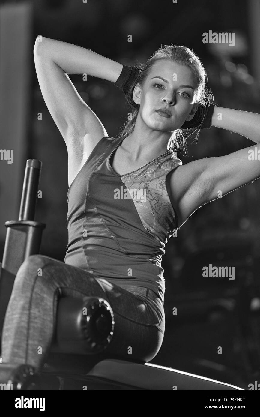 Frau Kraft-Übungen für Bauchmuskeln bei indoor-Sport-Fitness-Studio zu tun. Mädchen tun Yoga erstreckt sich nach dem laufen. Fitness-Modell in dunklen Sportclub. B Stockfoto