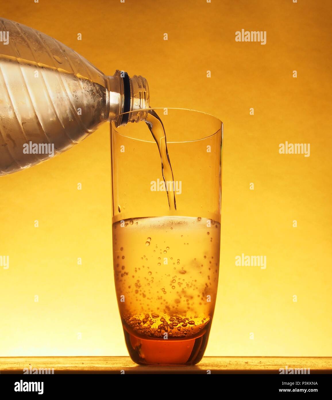 In einem Glas mit kaltem Mineralwasser aus Plastikflaschen gefüllt. Still-Leben. Stockfoto