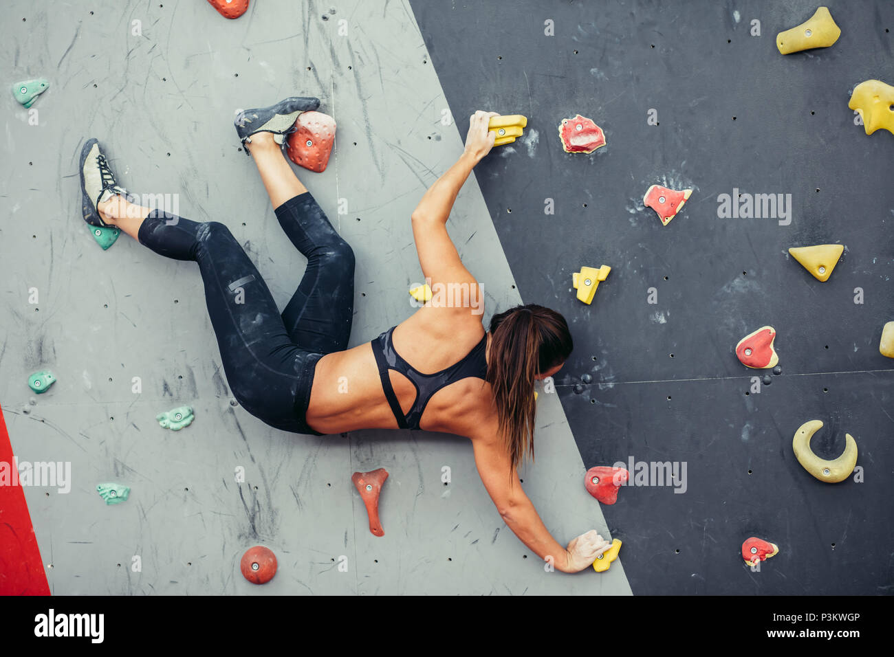 Schöne junge Frau einen großen Schritt bis eine künstliche Wand Stockfoto