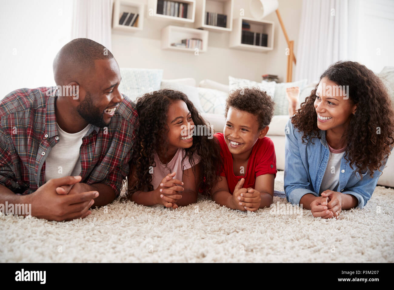 Familie liegen auf Teppich im Wohnzimmer zu Hause. Stockfoto