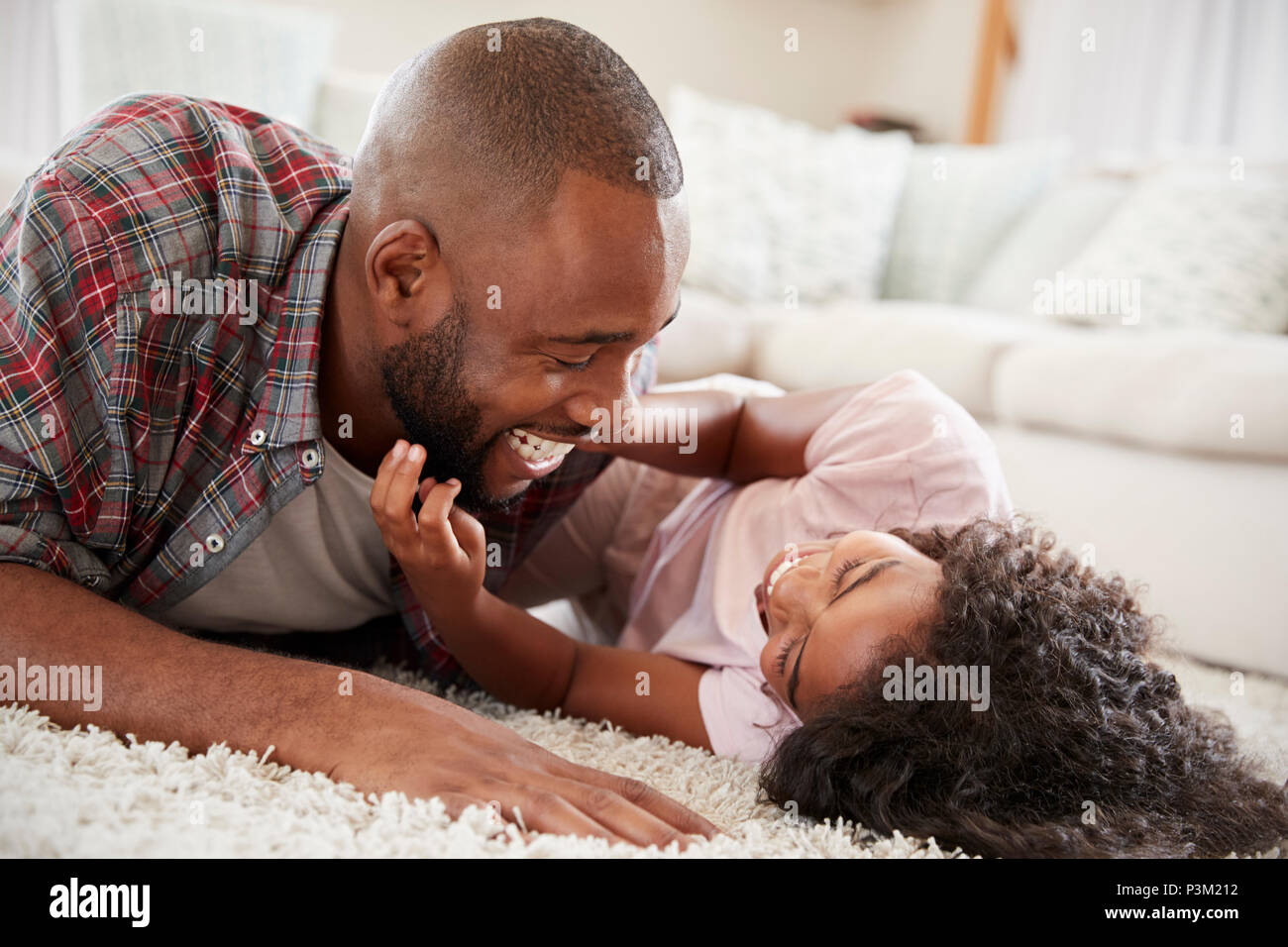 Vater kitzeln Tochter, wie Sie spielen Spiel in der Lounge zusammen Stockfoto