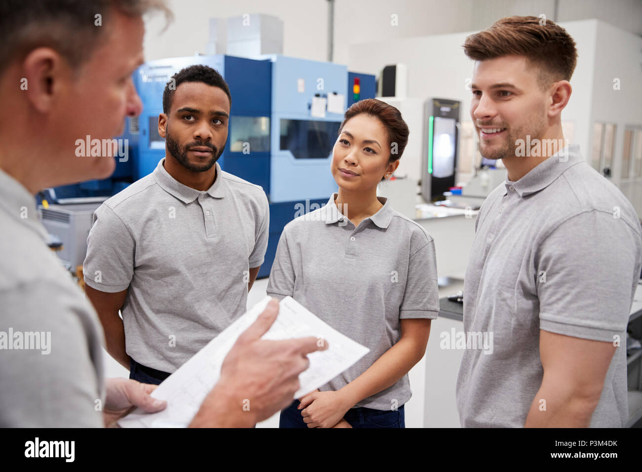 Engineering Team Meeting auf dem Boden des geschäftigen Workshop Stockfoto