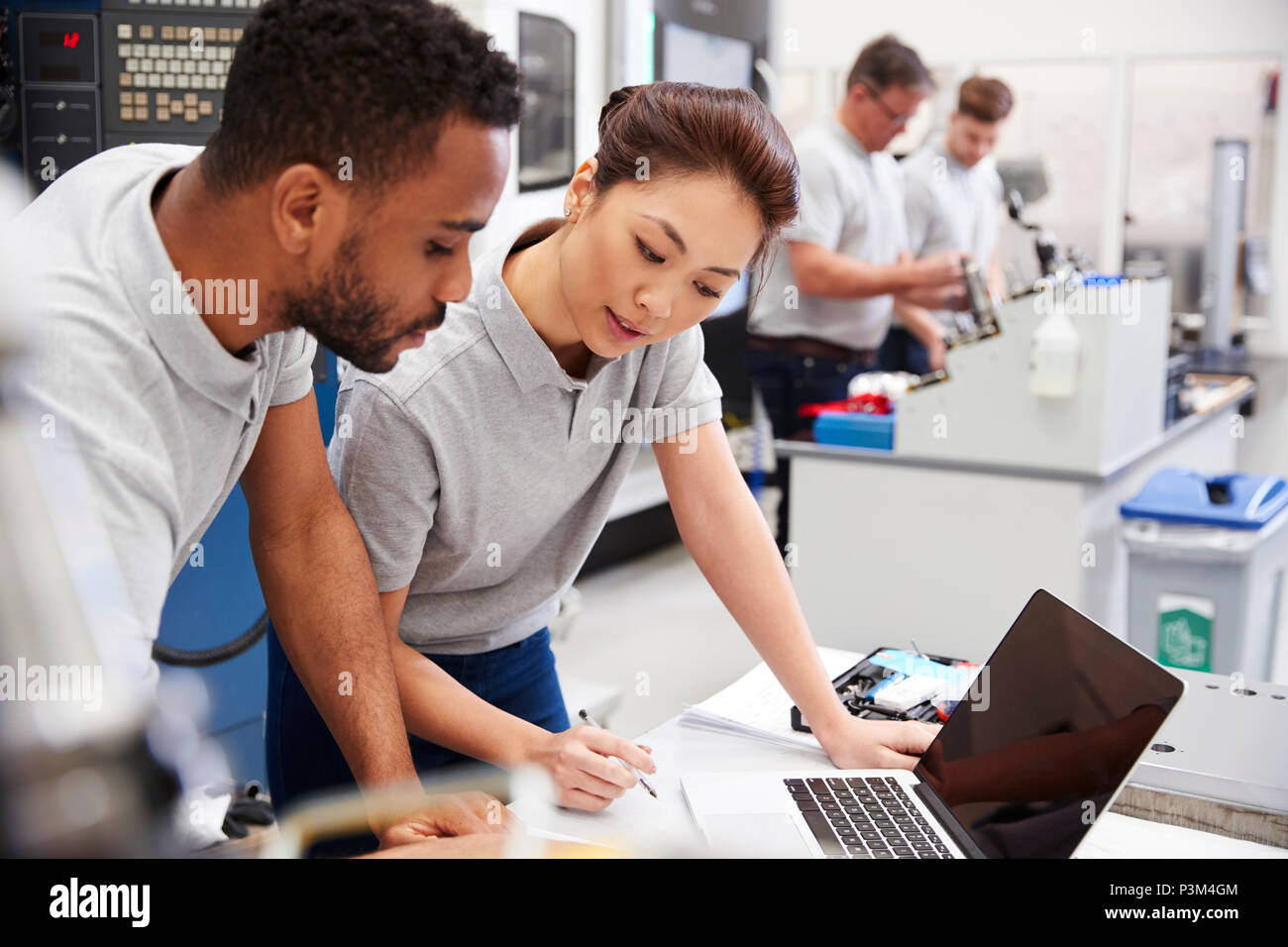 Zwei Ingenieure, die mit CAD-Programmierung Software auf dem Laptop Stockfoto