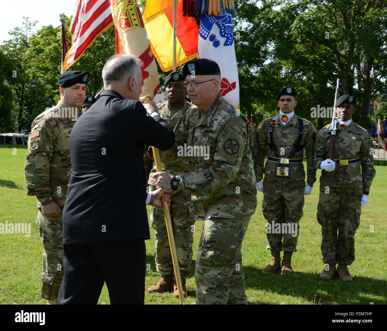 Oberst G. Shawn Brunnen, Jr., ausgehende U.S. Army Garrison Rheinland-Pfalz Commander, übergibt die Garnison Farben von Herrn Michael Formica, Direktor, Installation Management Command-Europe Region während der Garnison Ändern des Befehls Zeremonie, 6. Juli 2016 Daenner Kaserne, Kaiserslautern, Deutschland. (U.S. Armee Foto von visuellen Informationen Spezialist Elisabeth Paque/Freigegeben) Stockfoto