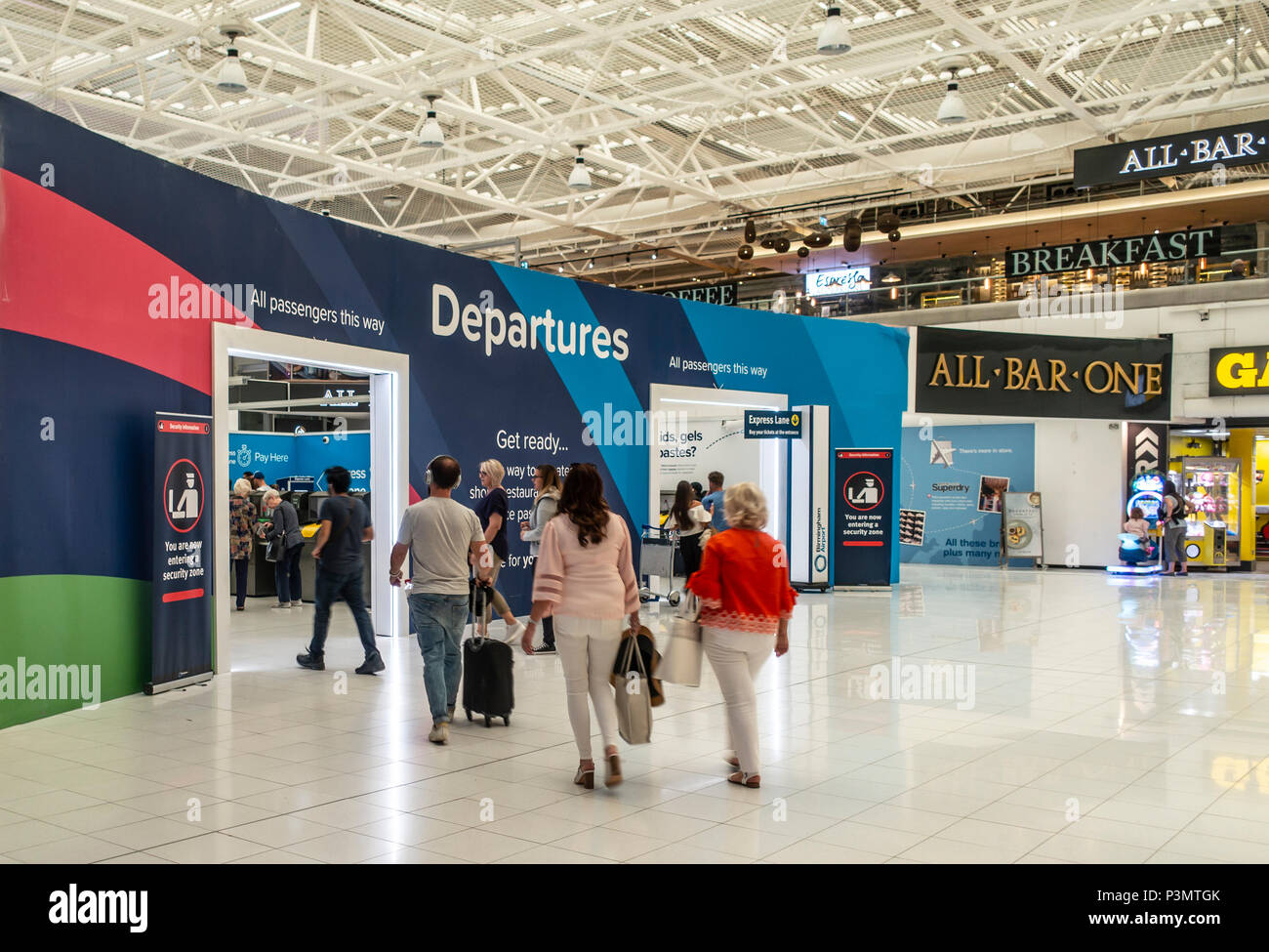 Fahrgäste in Richtung Abflugbereich der Internationale Flughafen Birmingham, England, UK. Zeichen für All Bar One Restaurant. Stockfoto