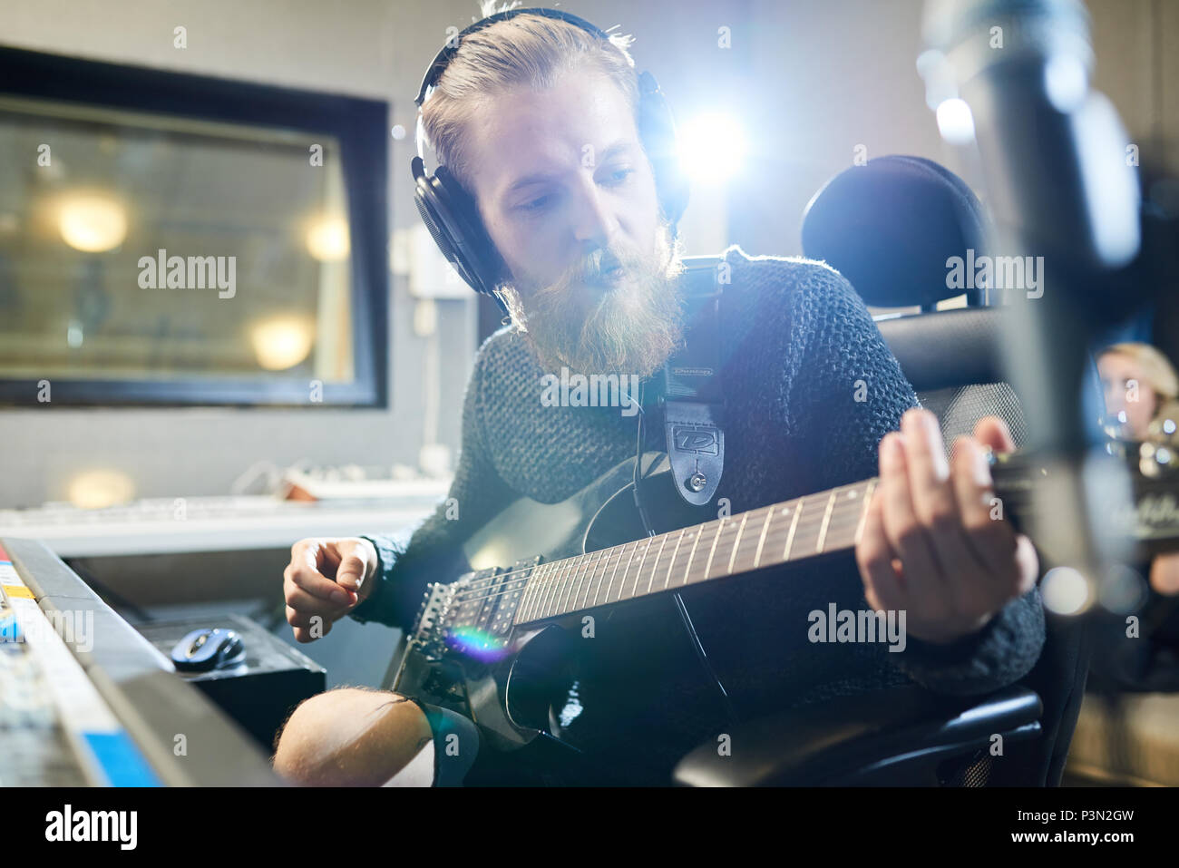 Bärtige Musiker mit Gitarre in Sound Studio Stockfoto