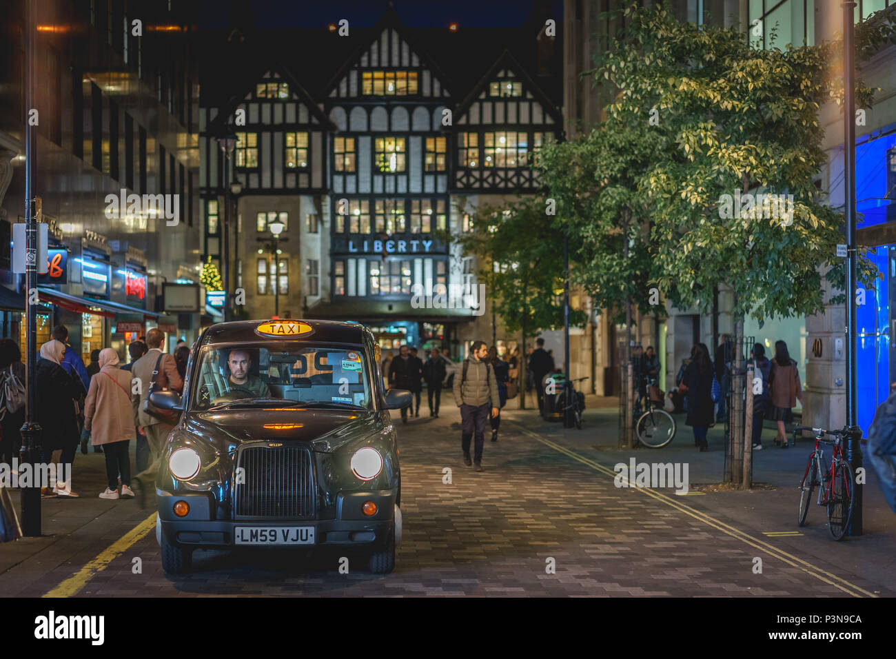 London, UK, November 2017. Die Menschen wandern vor der Liberty high class Kaufhaus in Soho in der Nacht während der Weihnachtszeit. Stockfoto