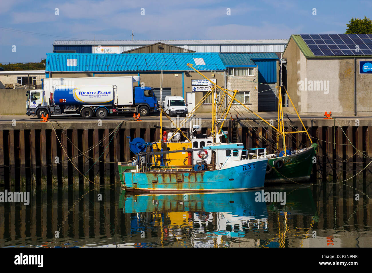 Vom 7. Juni 2018 verschiedene farbige Fischtrawler gebunden in den ruhigen Wassern der Kilkeel Harbour im County Down in Nordirland Stockfoto