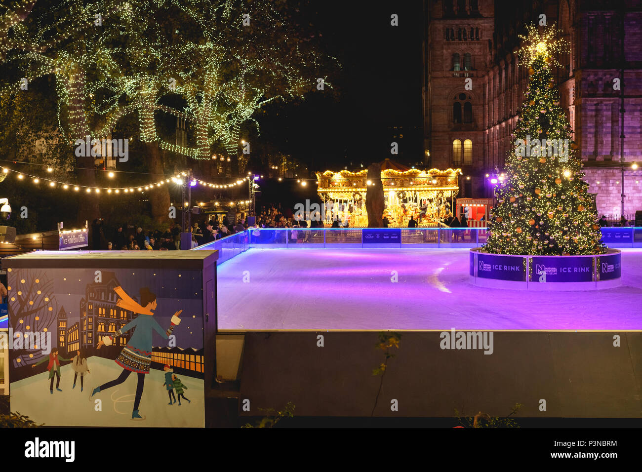 London, UK, Dezember 2017. Nacht Blick auf die Eisbahn und das Karussell am National History Museum, mit Weihnachtsschmuck. Stockfoto
