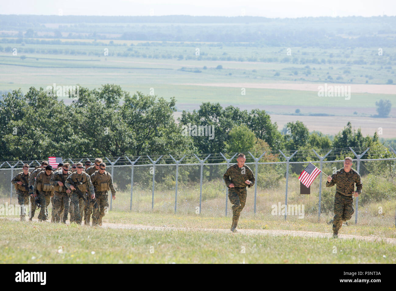 U.S. Navy LT Saul L. Burleson, Kaplan mit Schwarzen Meer Drehkraft, hält eine amerikanische Flagge, als er eine Gruppe von Marines in einen Kader endurance Kurs während der Übung Platin Lion16-4 an Bord Novo Selo, Bulgarien, 14. Juli 2016 führt. Dieser multinationalen Übung vereint acht NATO- und Partnerstaaten für eine Live-fire Übung sollen regionale Verteidigung in Osteuropa zu stärken. (U.S. Marine Corps Foto von Cpl. Kelly L. Straße, 2 D MARDIV COMCAM/Freigegeben) Stockfoto
