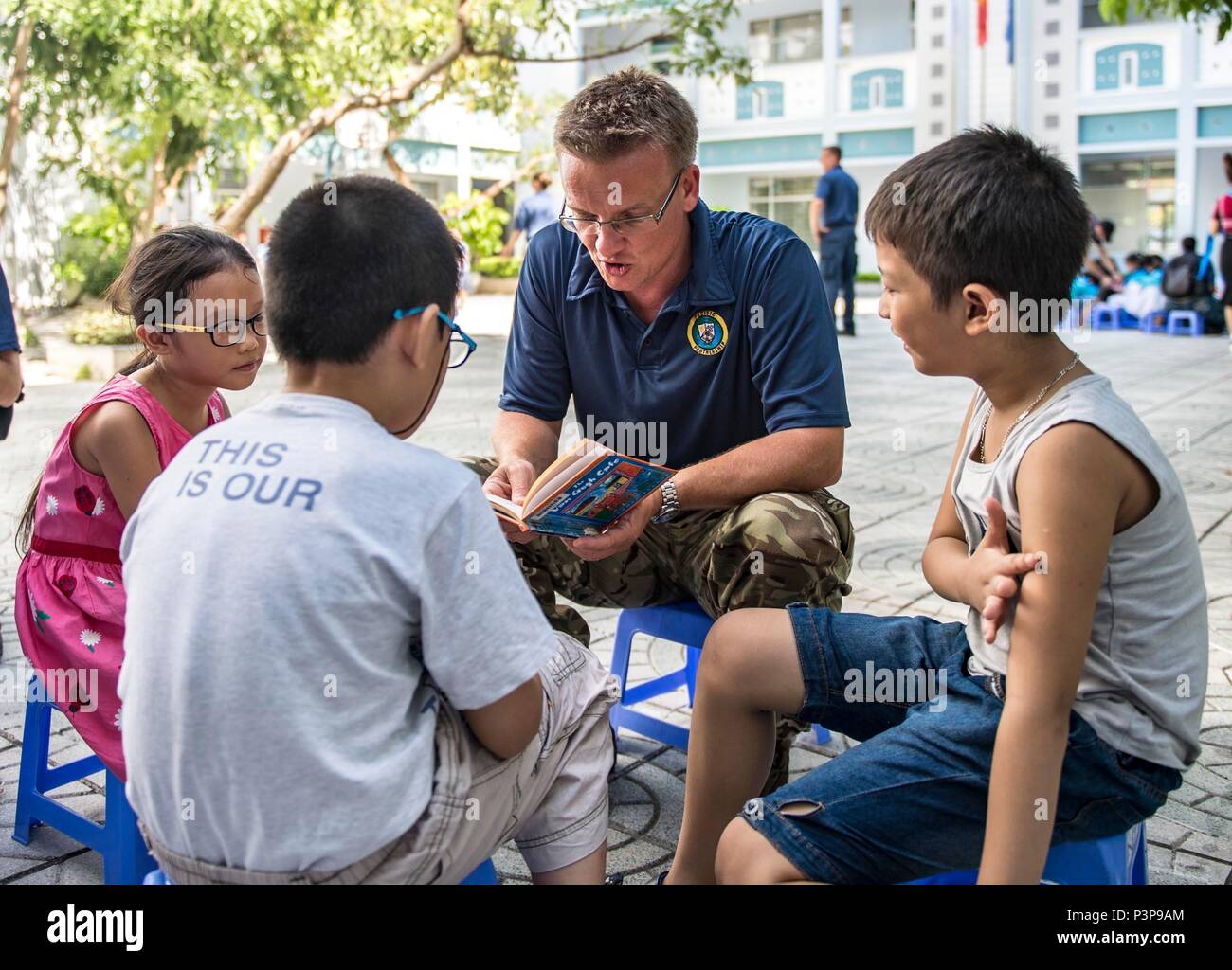 160719-N-SJ 730-038 Da Nang, Vietnam (19 Juli 2016) Großbritannien Royal Navy Cmdr. Karl Drummond, ein Zahnarzt, liest, die vietnamesischen Kinder während einer pazifischen Partnerschaft Englisch Konversation Gemeinschaft Bezug 2016 Veranstaltung. Hospital Ship USNS Mercy (T-AH 19) wird von JS Shimokita (LST-4002) und des vietnamesischen Volkes Schiff der Marine, Khánh Hóa für Pazifische Partnerschaft verbunden. Partner Nationen arbeiten Seite an Seite mit lokalen Organisationen kooperative Gesundheit Projekte zu leiten, die Beziehung und den Austausch von Experten besser für natürliche Katastrophe oder Krise vorbereiten. (U.S. Marine Foto von M Stockfoto