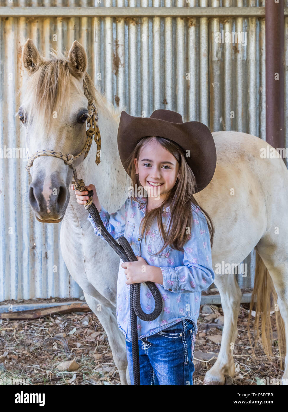 Junge australische Mädchen, trug einen Stetson, halten auf ihrem Pony im Stall. Stockfoto
