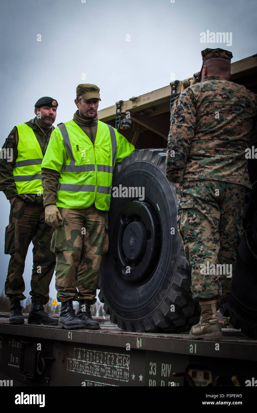 Norwegische Staff Sgt. Cteinar Norli, ganz links, und Kapitän Andre Gjerde sprechen mit US Marine 2. Lt Bryan Hassett, Recht, ein Logistics Officer mit 2. Transport Support Bataillons, Bekämpfung der Logistik Regiment 2, 2 Marine Logistics Group, nach Marines eine 7-Tonnen-LKW auf einen Triebwagen in der Hölle, Norwegen, 9. Mai 2017 geladen. Die Operationen des Schienenkopfes wurden durchgeführt als Teil der strategischen Mobilität Übung 17 (STRATMOBEX). STRATMOBEX konzentrierte sich auf die Einsatzbereitschaft und Mobilität von Anlagen in Norwegen. Stockfoto