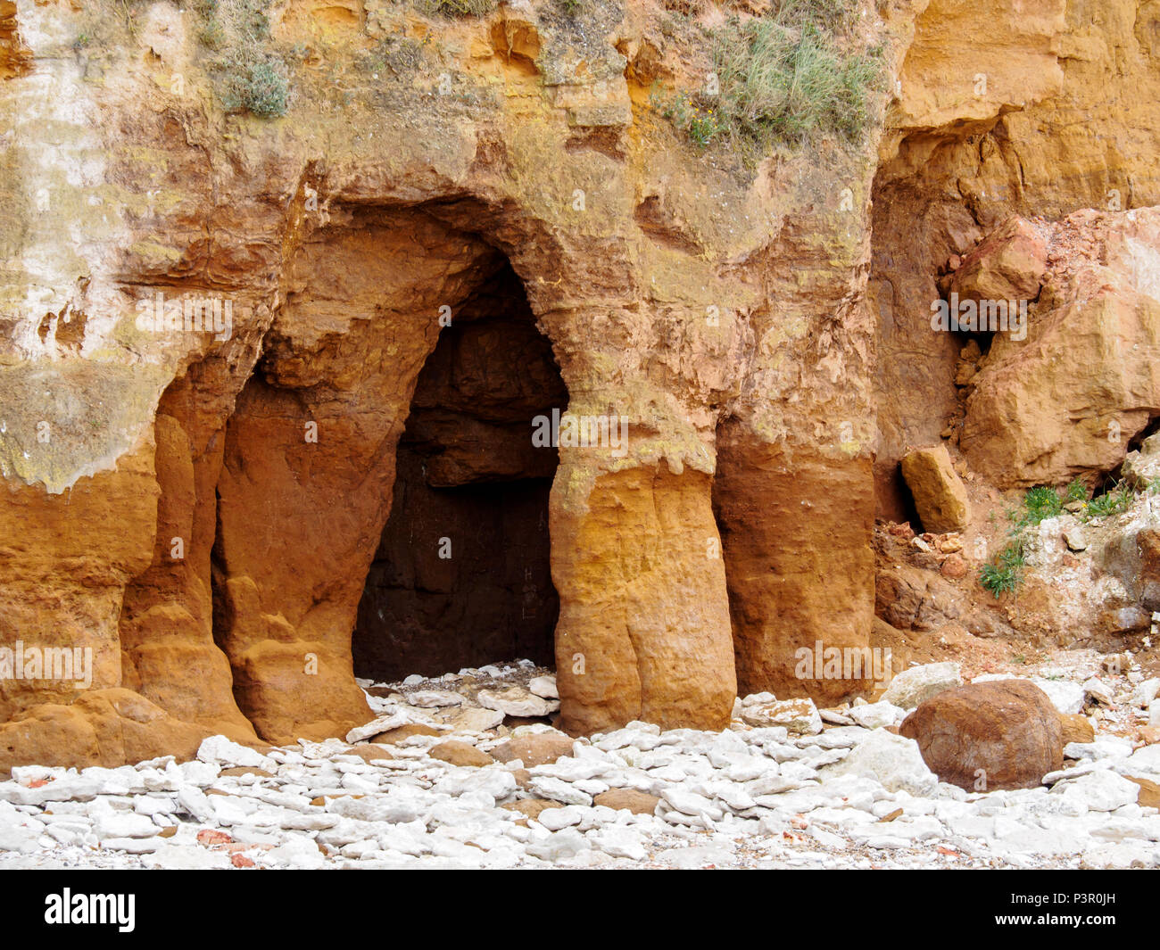 Kleine Höhle in der carstone Schichten von Old Hunstanton Klippen demonstrsating die Auswirkungen der Marine erosion. Stockfoto