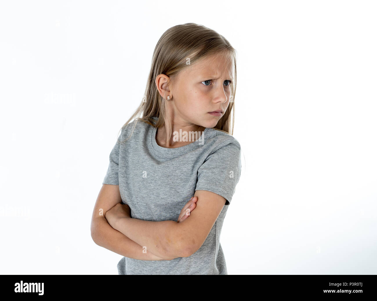 Portrait von wütend, traurig und deprimiert kleine blonde Mädchen auf weißem Hintergrund. Kinder's Gesicht Emotionen Konzept Stockfoto