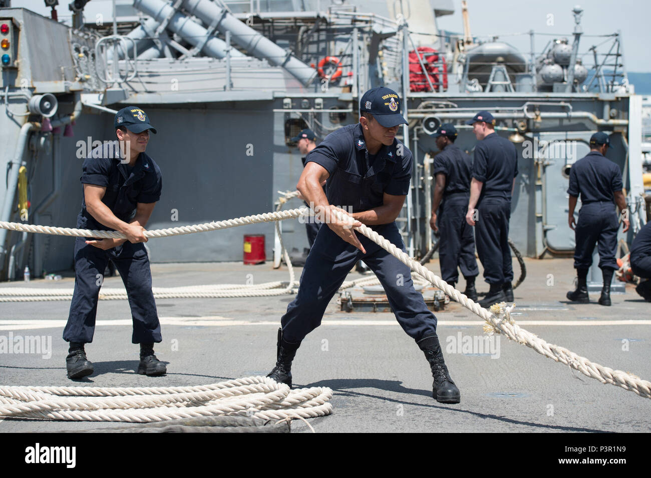 160722-N-UF 697-020 Sasebo Harbor, Japan (Juli 22, 2016) Information Systems Techniker 3. Klasse Isaac Flores, rechts, und Informationssysteme Techniker 3. Klasse Jeremy N. Ovalle, Links, zugeordnet zu den zukunftsweisenden Einsatz der Arleigh-Burke-Klasse geführte Anti-raketen-Zerstörer USS Barry (DDG52), hebe eine Leine, als das Schiff den Hafen von Sasebo, Japan fährt. Barry ist auf Patrouille in den USA 7 Flotte Bereich für Maßnahmen zur Erhöhung der Sicherheit und Stabilität in der Indo-Asia - Pazifik. (U.S. Marine Foto von Mass Communication Specialist 2. Klasse Kevin V. Cunningham/Freigegeben) Stockfoto