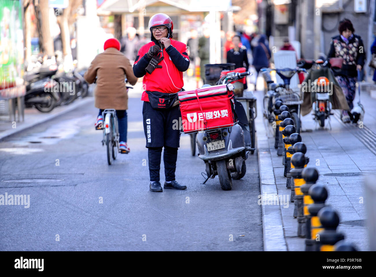 Peking, China - MÄRZ 10, 2016: Food Delivery Kurier mit Motorroller brachte Aufträge an Kunden. Stockfoto