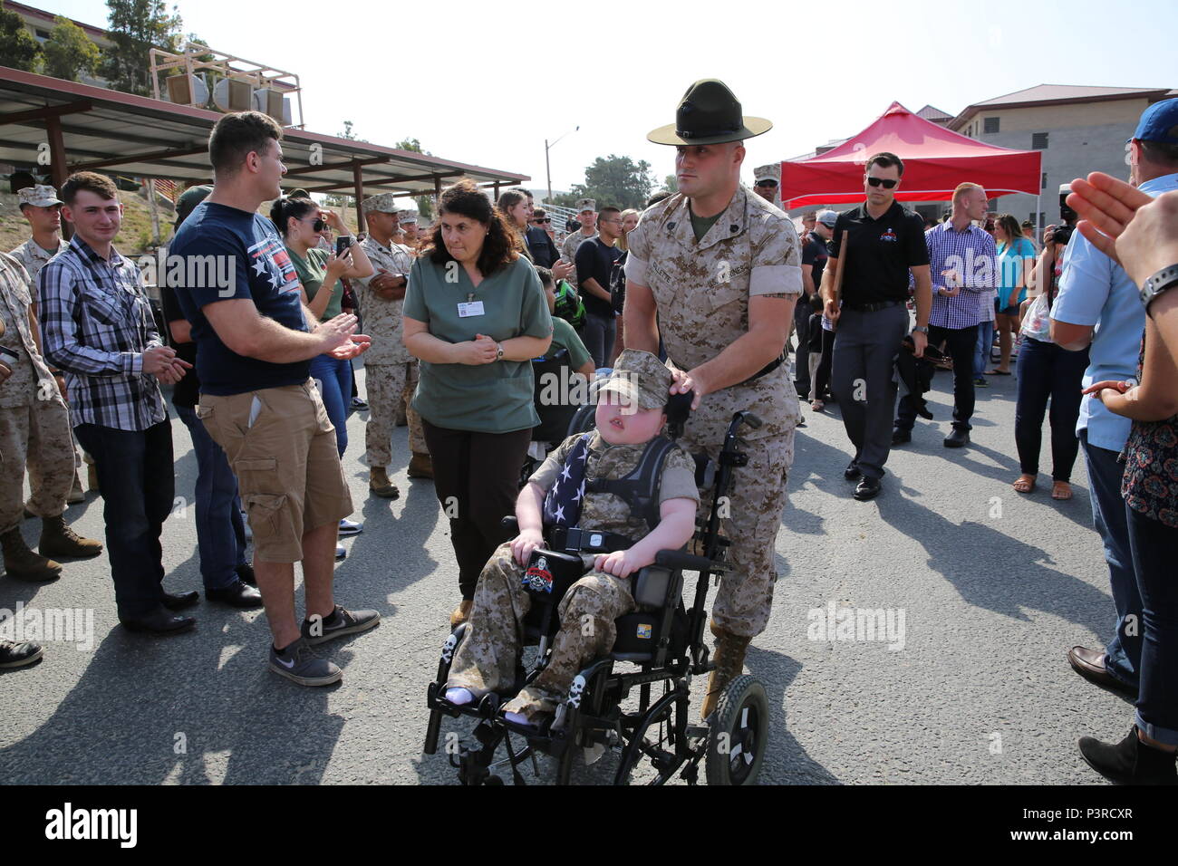 Staff Sgt. Jeremia Gillette, Senior drill instructor, Marine Corps Recruit Depot San Diego, Spaziergänge mit seinem Sohn Wyatt Gillette nach betitelt wird ehrenamtlich Marine am 30. Juli 2016 Marine Corps Base Camp Pendleton, Calif Wyatt mit Goutierres Aicardi Syndrom mit trex1 Mutation, die ist ein Syndrom, das mehrere medizinische Ausgaben für Wyatt verursacht hat bestimmt wurde. Stockfoto