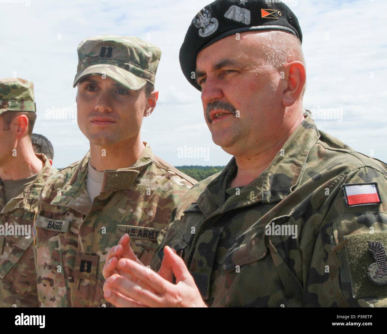 TRZEBIEN, Polen - Generalmajor Jaroslaw Mika, der Kommandant der 11 Lubuska gepanzerte Kavallerie Division, Polnische Armee, spricht mit Kapitän Colin Baggs, Kommandant des Unternehmens D, 3. Kombinierte Waffen Battalion, 69th Panzer Regiment, 3 Infanterie Division, während einer Live Fire Training übung in Trzebien, Polen, 19.Juli. Soldaten der D Co., 3., 69.. Rgmt., feuerte Javelin Panzerabwehrraketen und M136 bei 4 anti-tank Waffen während der Veranstaltung, die auch die Unterstützung durch Feuer Vermögenswerte aus der polnischen Armee. Die Übung fördert die Interoperabilität zwischen US-amerikanischen und der Polnischen Streitkräfte im Rahmen der Operation Atlantik Stockfoto