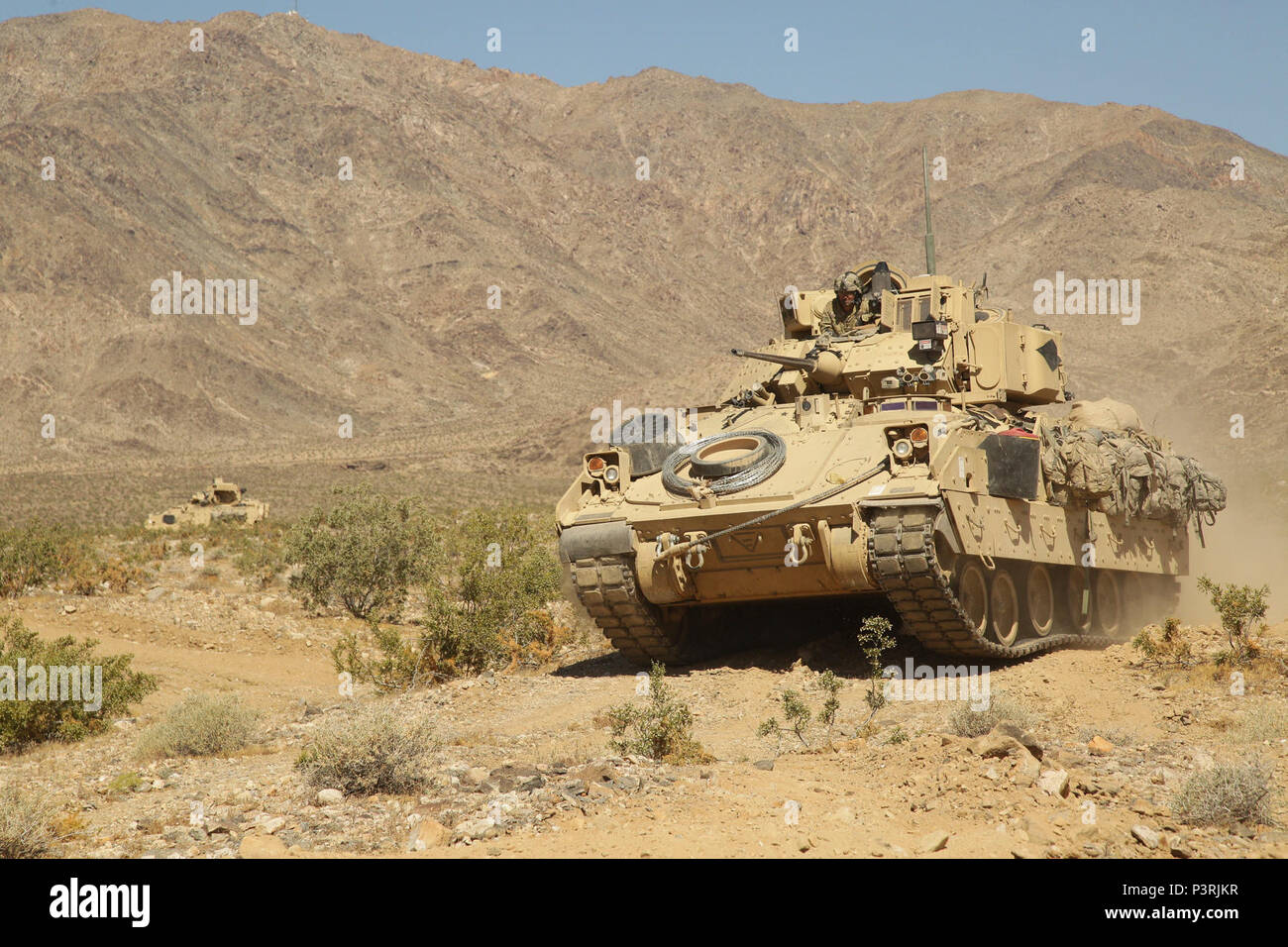 Us-Soldaten auf das erste Bataillon zugeordnet, 63 Armored Regiment, 2nd Brigade Combat Team, 1.Infanterie Division, verschieben Angriff ein Ziel während der entscheidenden Aktion Rotation 17-06 an der National Training Center, Fort Irwin, Calif., 7. Mai 2017. Stockfoto