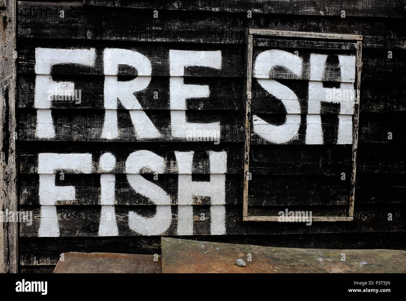 Frischer Fisch Zeichen gemalt auf schwarz Beach Hut, Hastings, East Sussex, England Stockfoto