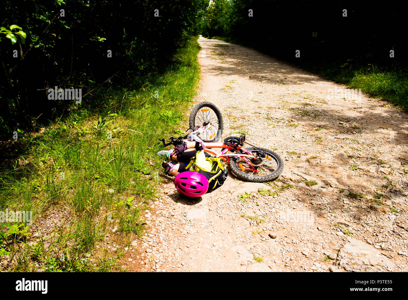 Kleines Mädchen fällt ihr Fahrrad Stockfoto