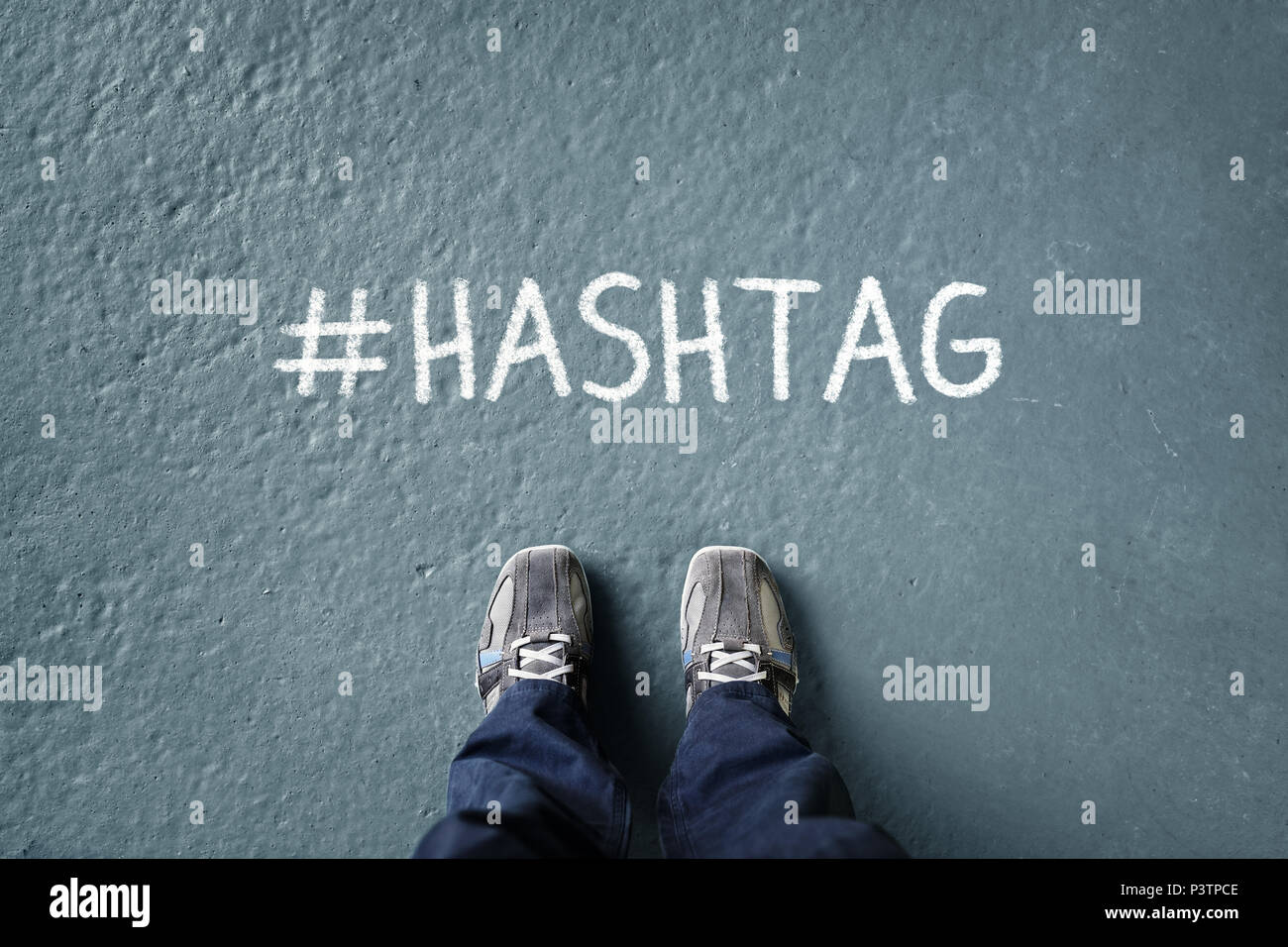 Soziales Netzwerk Hashtag auf dem Boden mit Mann stand unten auf der Suche Konzept für Trends, Marketing und Media Stockfoto