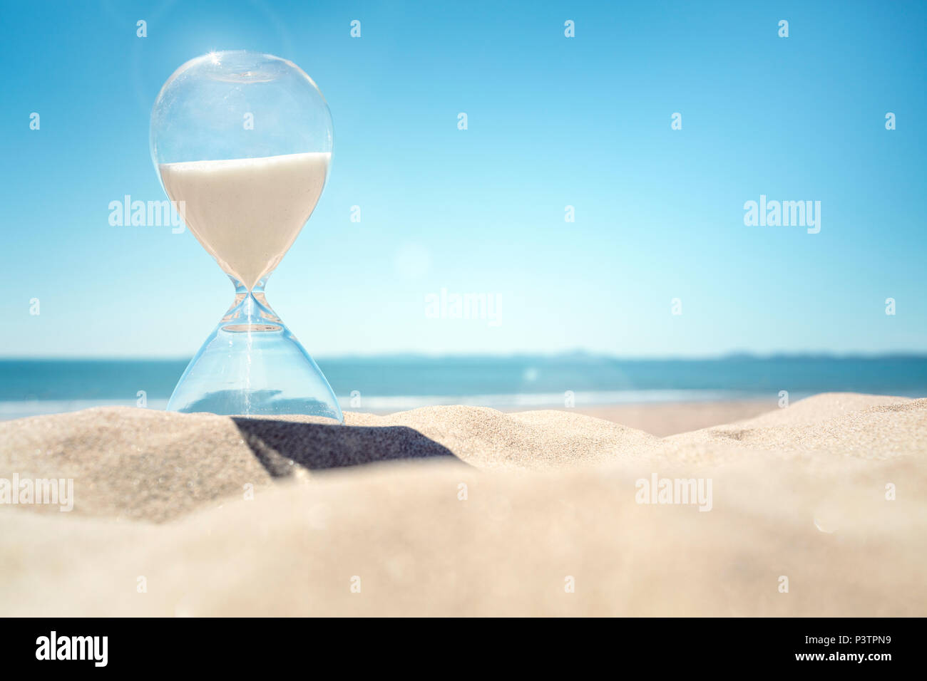 Sanduhr Zeit am Strand in den Sand mit blauem Himmel und Kopie Raum Stockfoto