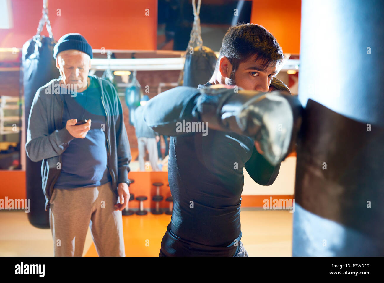 Man Boxsack mit Trainer Workout Stockfoto