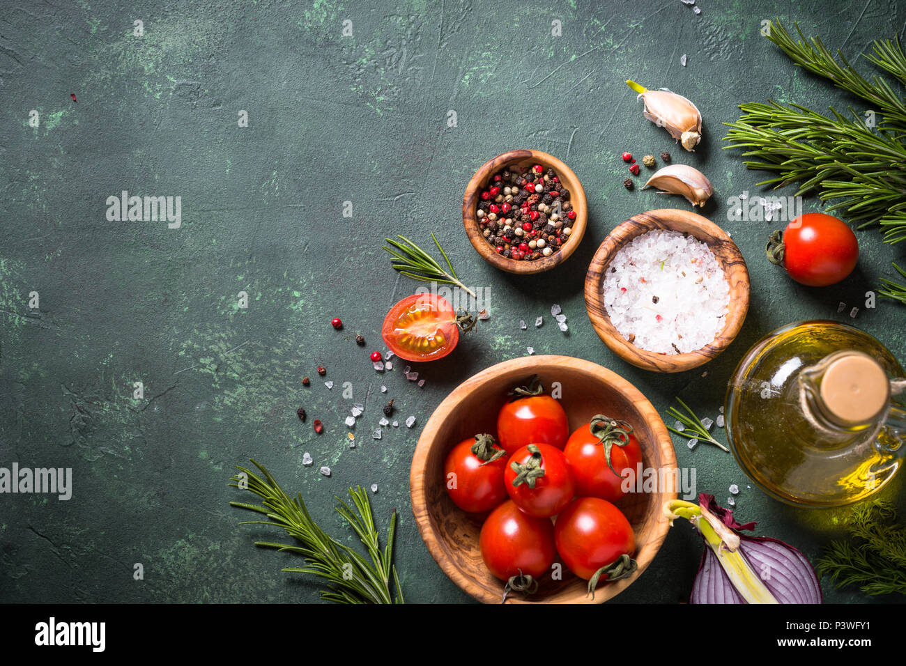Essen Hintergrund mit Gewürzen, Olivenöl und Tomaten auf Tisch aus Stein. Zutaten zum Kochen. Ansicht von oben mit der Kopie. Stockfoto