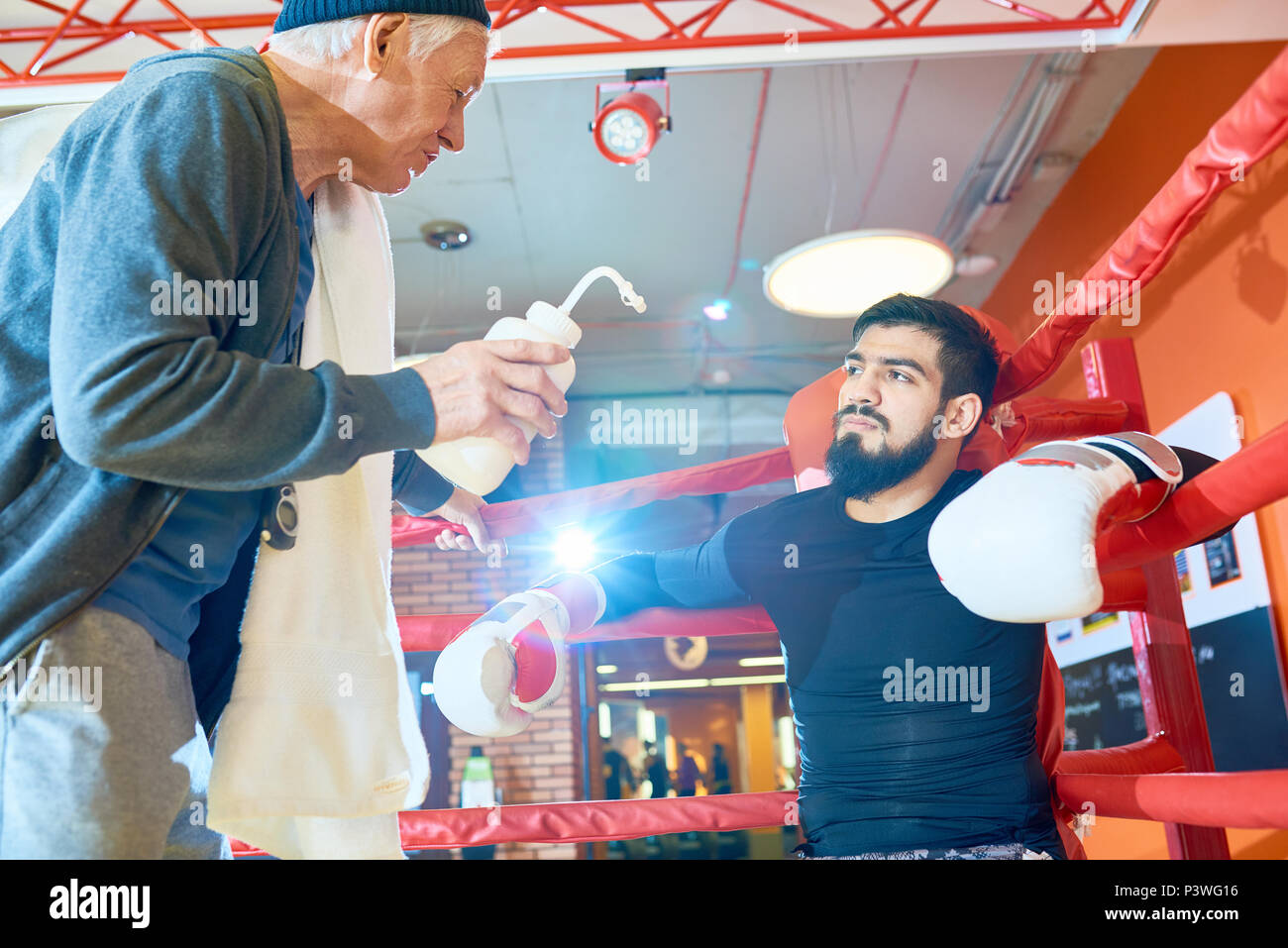 Ernster mann Boxen mit Trainer Stockfoto