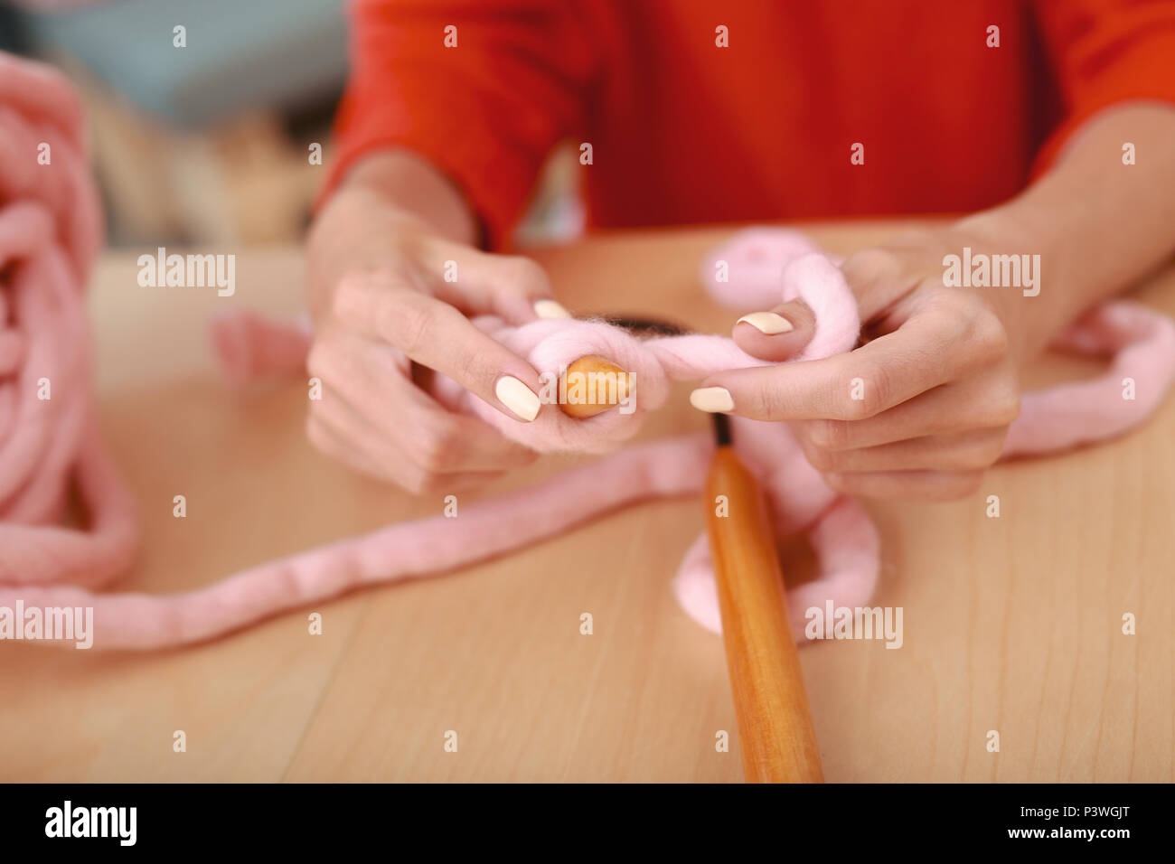 Geschickte needlewoman Knitting schön rosa Pullover Stockfoto